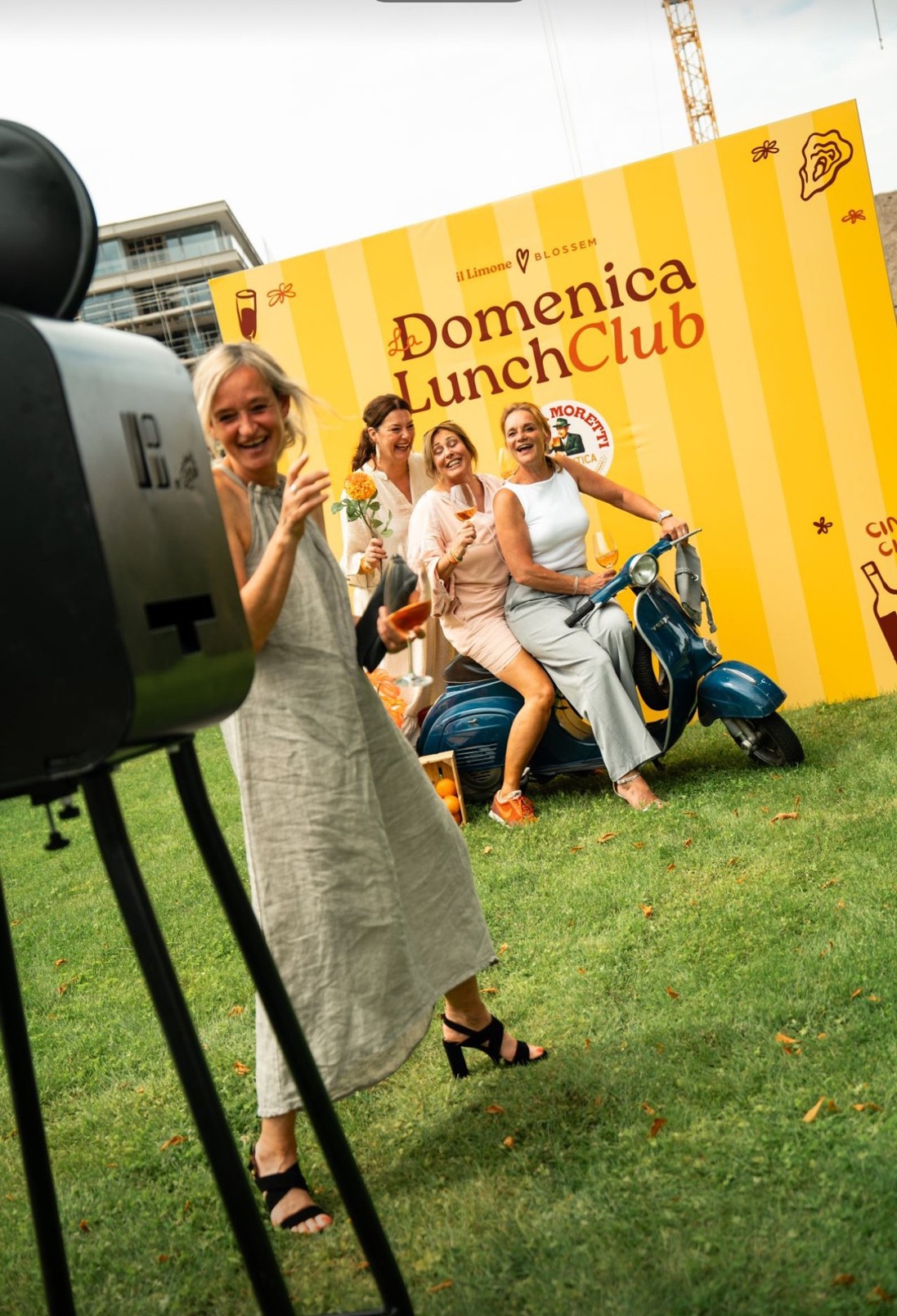 Lachende dames die gebruik maken van een photobooth op een scooter